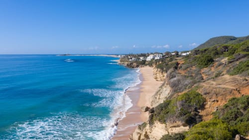 Costa mediterránea turquesa con playa de arena, villas encaladas y acantilados espectaculares cerca de Cádiz