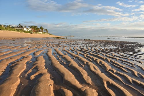 Playa con arena ondulada y aguas someras en Casa De La Cruz Vejer, resort costero de Cádiz