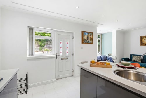Modern kitchen in St Augustine's Place apartment, Birmingham, featuring white cabinetry, grey countertops, and stainless