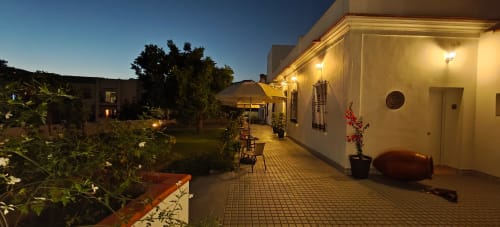 Patio nocturno del Hotel Boutique Alcazaba Salobreña con iluminación, plantas en macetas y sombrillas