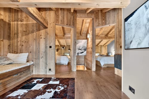 Chambre du chalet de luxe L'Alp'In avec lits multiples, poutres apparentes et équipements modernes à La Plagne.