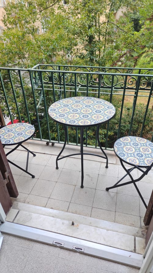 Terrazza con tavolo e sedie a motivi blu che affacciano su un lussureggiante giardino della Roma B&B