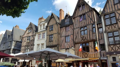 Bâtiments à colombages du Moyen Âge avec parasols de marché sur une place de village français