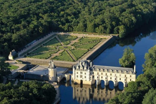 Château de Chenonceau enjambant la rivière avec jardins à la française, entouré de forêt en Vallée de la Loire, France