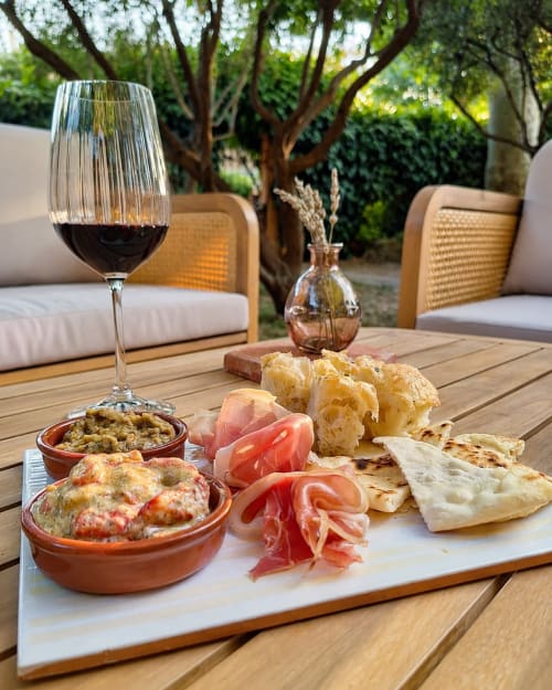 Vin, charcuterie et amuse-bouches sur une table en bois à l'Auberge du Parc à Correns, France