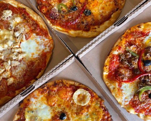 Pizzas fraîchement cuites au fromage fondu et garnitures à Domaine Les Racines B&B à Croix-Moligneaux