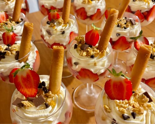 Élégants parfaits garnis de crème fouettée, fraises, granola et biscuits croustillants aux Racines