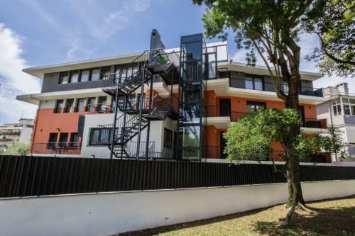 Modern J Home apartment building in Prior Velho, Lisboa, with orange and white façade, spiral staircase, and black metal