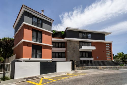 Modern J Home apartment building in Prior Velho, Lisboa with orange and black facade, near train station and park