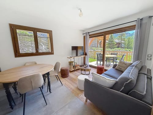 Espace de vie moderne dans l'appartement La Tanière du Tétras, Montgenèvre, avec table à manger, canapé gris et vue sur la montagne