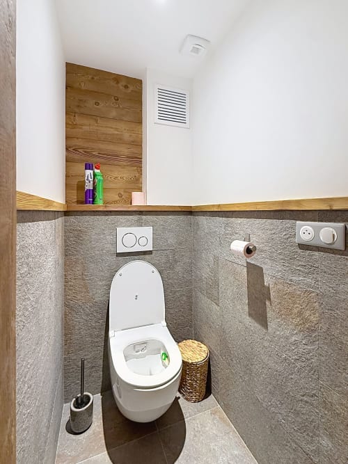 Toilettes modernes avec bouton double-chasse dans la salle de bain de l'appartement La Tanière du Tétras, Montgenèvre