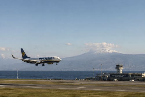 Aereo Ryanair in atterraggio all'aeroporto di Reggio Calabria con l'Etna e il mare sullo sfondo