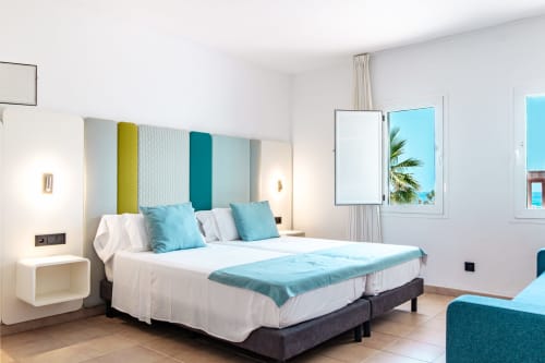 Moderno dormitorio doble en Smart Hotel Cabo Sur, Mojácar con vistas al océano, acentos turquesas y ventanales frente al mar