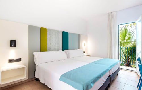 Luminosa habitación doble en Smart Hotel Cabo Sur de Mojácar con vistas al mar, cabecero colorido, ropa de cama blanca y balcón