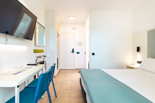 Habitación doble moderna en Smart Hotel Cabo Sur de Mojácar con dos camas, escritorio, TV y diseño minimalista luminoso