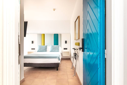 Moderna habitación del Smart Hotel Cabo Sur en Mojácar con cama queen, cabecero en turquesa, acceso a terraza y diseño minimalista