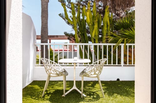 Terraza privada del Smart Hotel Cabo Sur en Mojácar con mesa blanca, sillas de diseño y vistas al mar
