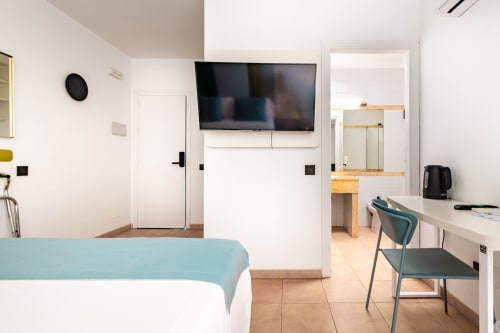 Habitación moderna del Smart Hotel Cabo Sur en Mojácar con cama, escritorio, TV y baño en suite