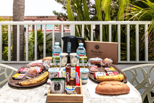 Desayuno de bienvenida en la terraza del Smart Hotel Cabo Sur, Mojácar con panes, pasteles, agua y productos lácteos