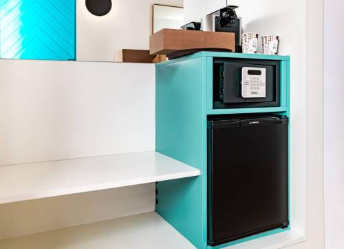 Kitchenette turquesa con microondas, mini nevera y encimera blanca en habitación del Smart Hotel Cabo Sur, Mojácar