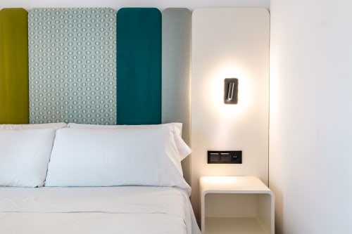 Habitación moderna en Smart Hotel Cabo Sur con cabecera acolchada colorida, ropa de cama blanca e iluminación junto a la cama en Mojácar