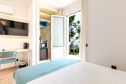 Moderno dormitorio doble en Smart Hotel Cabo Sur, Mojácar, con terraza, TV, kitchenette y decoración minimalista