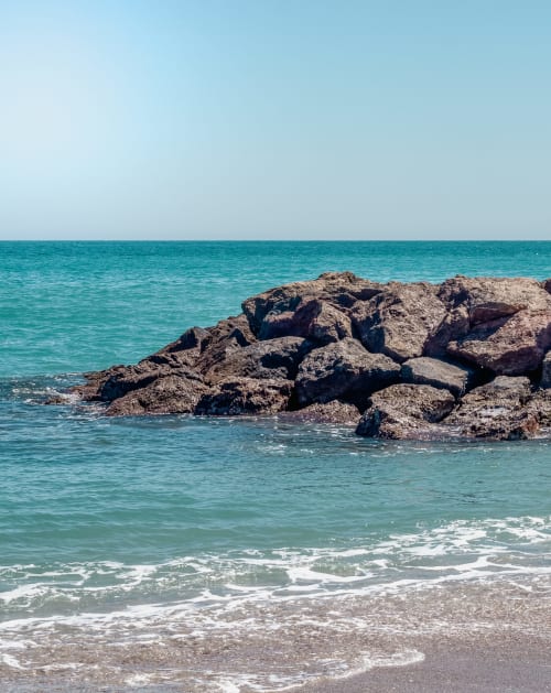 Aguas turquesas y costa rocosa en la playa del Smart Hotel Cabo Sur en Mojácar, España