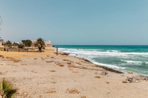 Playa de arena con aguas turquesas y palmeras en Smart Hotel Cabo Sur de Mojácar, España