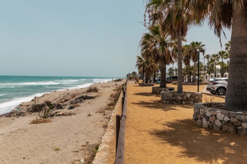 Paseo marítimo del Smart Hotel Cabo Sur en Mojácar con palmeras, playa de arena y vistas al mar Mediterráneo