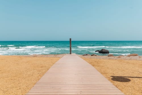 Pasarela de madera hacia el mar turquesa en la playa del Smart Hotel Cabo Sur, Mojácar, España
