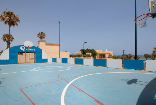 Cancha de baloncesto al aire libre del Smart Hotel Cabo Sur en Mojácar, España, con superficie azul y palmeras