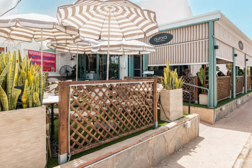 Patio exterior del Smart Hotel Cabo Sur en Mojácar con sombrillas rayadas, celosía y plantas desérticas
