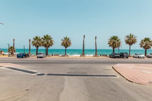 Paseo frente al mar del Smart Hotel Cabo Sur en Mojácar con palmeras, mar turquesa y coches aparcados