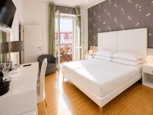 Camera matrimoniale deluxe al B&B Pellicano a Reggio Calabria con letto bianco, vista dal balcone e comfort moderni