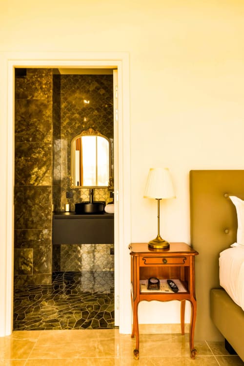 Élégante salle de bain attenante à l'Hôtel Villa Martini, Ajaccio avec carrelage en mosaïque dorée, vasque et miroir orné