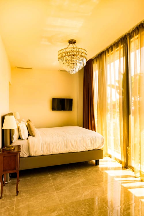Luxury sea view bedroom at Hôtel Villa Martini in Ajaccio with elegant chandelier, marble floors, and terrace doors