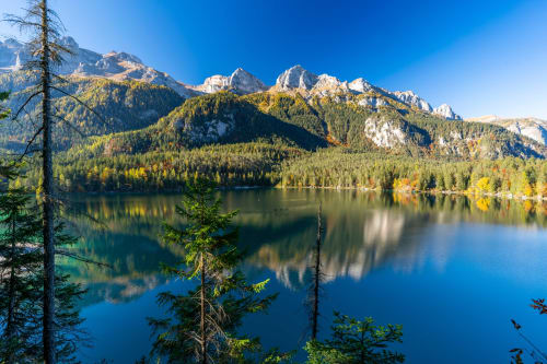 Lago alpino con vette montane e foresta presso Villa Rosati, Sanzeno, Trentino, Italia