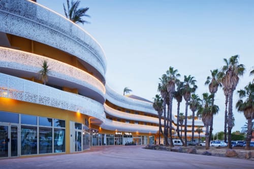 Immeuble blanc aux formes courbes modernes à Agde Luxury Loc avec palmiers, terrasse et parking au Cap d'Agde