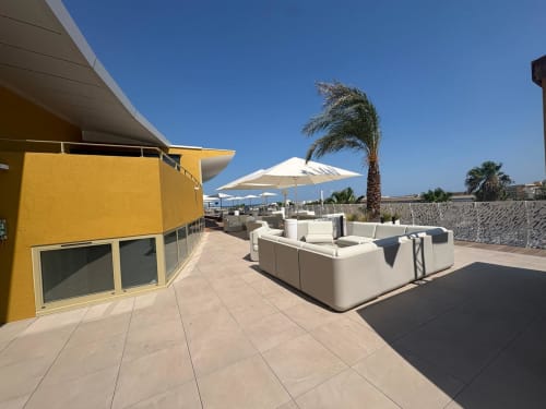 Terrasse avec vue océan à Agde Luxury Loc : salon blanc, parasols, palmiers, Cap d'Agde, France