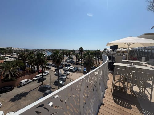 Vue de la terrasse sur le toit à Agde Luxury Loc avec palmiers, parking et accès à la mer à Cap d'Agde