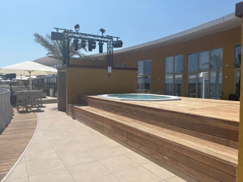 Terrasse panoramique d'Agde Luxury Loc avec piscine à débordement, terrasse en bois et immeuble moderne surplombant Cap d'Agde