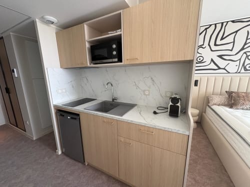 Cuisine moderne avec placards en bois, plan de travail en marbre et évier en acier inoxydable à l'appartement Vibes Infinity, Agde Luxury Loc