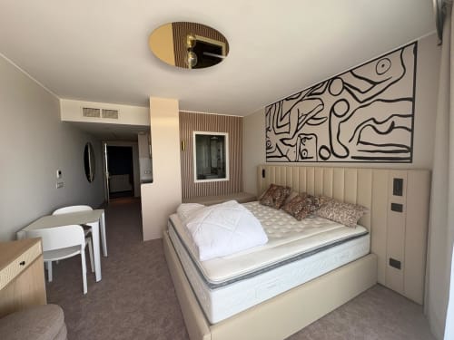 Chambre élégante à Agde Luxury Loc avec lit crème, art mural abstrait et espace de vie ouvert à Cap d'Agde, France