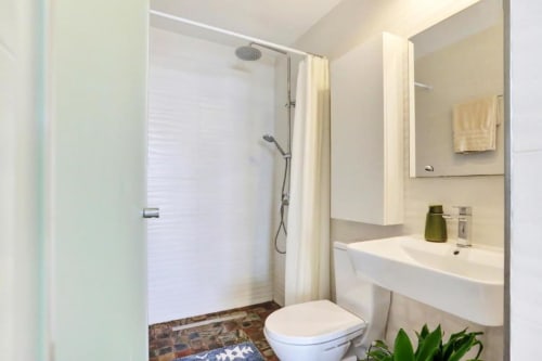 Baño moderno en apartamento Kamalahouse, Corralejo con ducha abierta, lavabo y toilette blancos