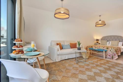 Moderno apartamento loft en Corralejo con zona de comedor, sofá, balcón con vistas al mar e iluminación colgante