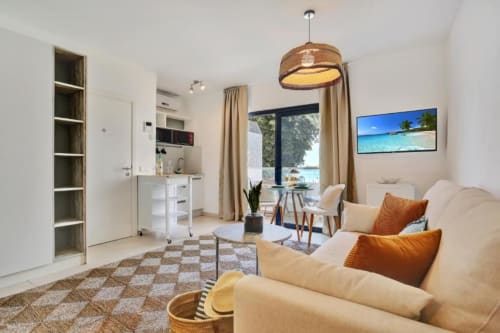 Moderno loft con vistas al mar en Corralejo, sofá crema, cocina americana, comedor y vista a la playa
