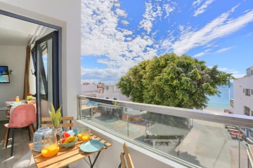 Zona de comedor en balcón del apartamento Kamalahouse SL en Corralejo con vistas al mar, mesa amueblada y paisaje costero