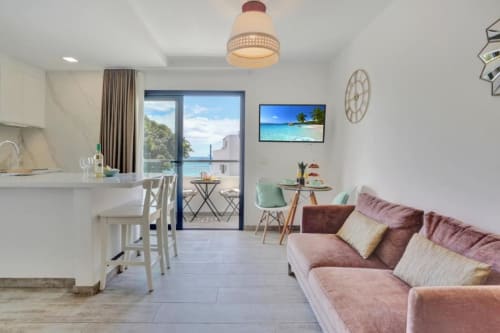 Moderno apartamento con vistas al mar en Corralejo, sala de estar abierta, cocina, comedor y balcón amueblado con vistas al