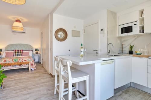 Moderno apartamento estudio en Corralejo con cocina blanca, comedor y dormitorio con vistas al mar