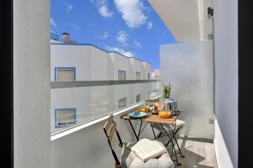 Balcón soleado con mesa de comedor, sillas y vistas al mar en loft de Corralejo